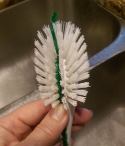 Cleaning scrub brush with pipe cleaner