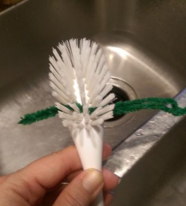 Cleaning scrub brush with pipe cleaner
